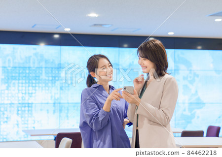 A young woman chatting while looking at her smartphone 84462218