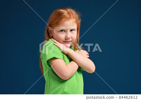 close up photo of little redhead emotional girl posing before camera on blue background close up photo of little redhead emotional girl posing before camera on blue background 84462612