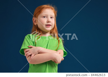 close up photo of little redhead emotional girl posing before camera on blue background close up photo of little redhead emotional girl posing before camera on blue background 84462613