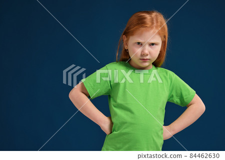 close up photo of little redhead emotional girl posing before camera on blue background close up photo of little redhead emotional girl posing before camera on blue background 84462630
