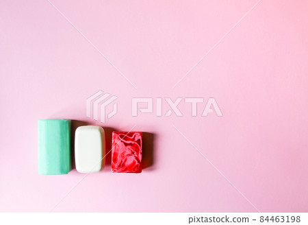 Different coloful soap on soft pink background 84463198