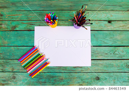 White paper sheet and school supplies on wooden aged background. White paper sheet and school supplies on wooden aged background. 84463349
