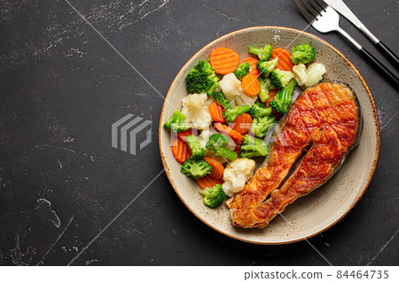 Grilled salmon steak with vegetables salad from above copy space Grilled salmon steak with vegetables salad from above copy space 84464735