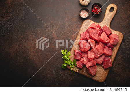 Beef raw meat cubes for stew on wooden cutting board copy space 84464745
