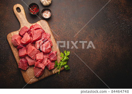 Beef raw meat cubes for stew on wooden cutting board copy space 84464748