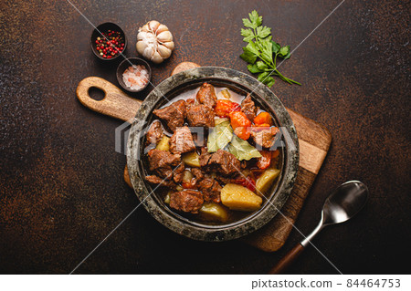 Meat beef stew with vegetables and gravy in rustic metal pot top view Meat beef stew with vegetables and gravy in rustic metal pot top view 84464753