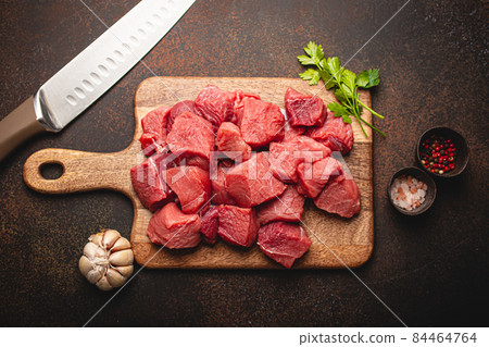 Beef raw meat cubes for stew on wooden cutting board 84464764