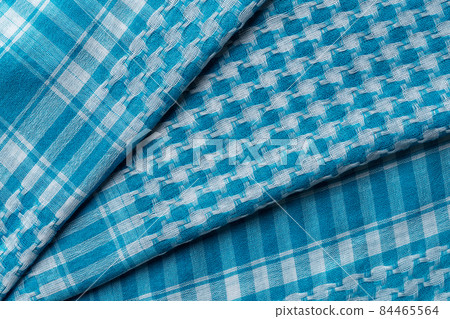 Folded keffiyeh of azure white colors background. Folded keffiyeh of azure white colors background. 84465564
