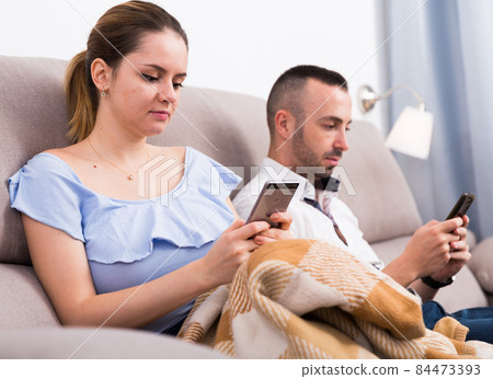 Married couple using mobile phones Married couple using mobile phones 84473393