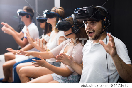 Excited man experiencing with friends virtual reality 84473612