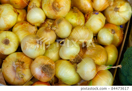 Bulb onion in plastic box on counter in grocery store 84473617