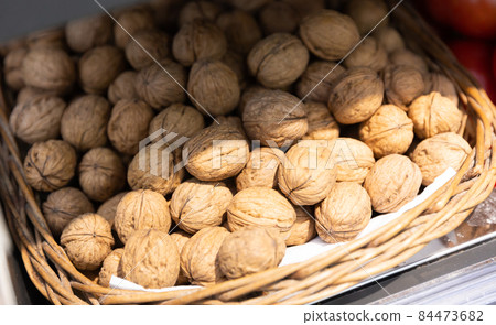 Whole walnuts with brown nutshells on retail market closeup Whole walnuts with brown nutshells on retail market closeup 84473682