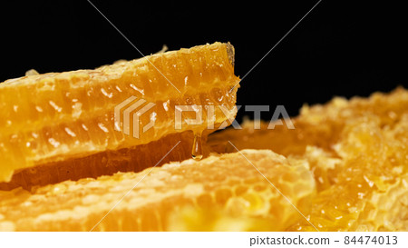 Drop of honey on honeycomb cut. Honeycomb slice Drop of honey on honeycomb cut. Honeycomb slice 84474013