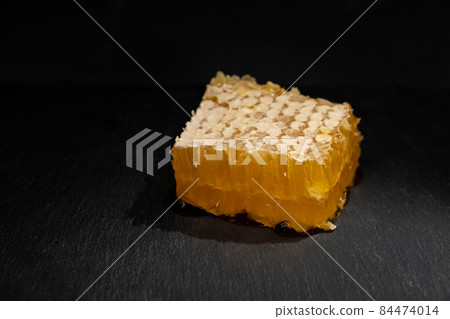 Sweet piece of honey in combs on black. Organic product theme Sweet piece of honey in combs on black. Organic product theme 84474014