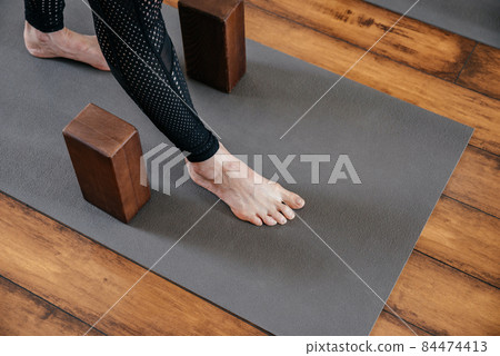 Cropped view of woman stretching her legs in yoga studio with yoga blocks Cropped view of woman stretching her legs in yoga studio with yoga blocks 84474413
