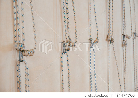 Yoga ropes hanging on empty studio wall. Iyengar yoga concept Yoga ropes hanging on empty studio wall. Iyengar yoga concept 84474766