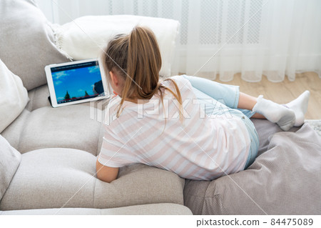 Girl Lying On Couch And Using Tablet Girl Lying On Couch And Using Tablet 84475089