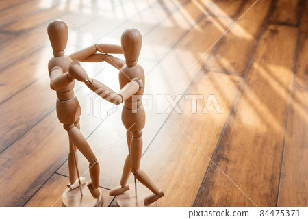 Wooden dolls standing on a floor in dancing pose 84475371