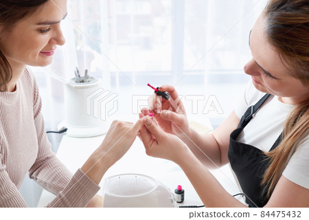 Woman getting a manicure at the nail salon Woman getting a manicure at the nail salon 84475432