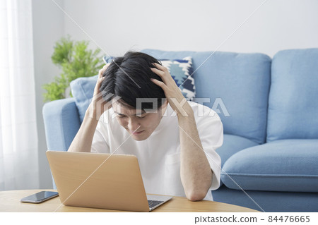 Male computer living room holding head 84476665