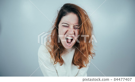 Close-up portrait of insane woman in straitjacket on white background. Close-up portrait of insane woman in straitjacket on white background. 84477407