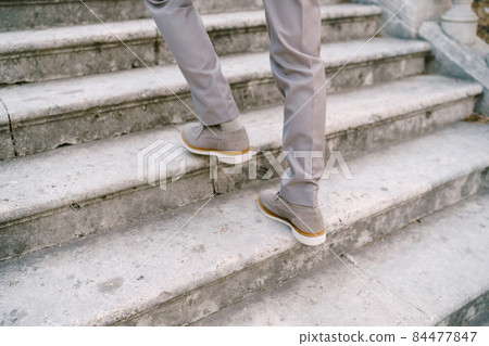 Male feet on stone steps. Close-up 84477847