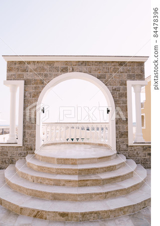 Arched balcony with balustrade and steps overlooking the Lustica bay. Montenegro Arched balcony with balustrade and steps overlooking the Lustica bay. Montenegro 84478396
