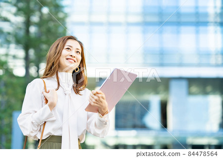 Female using a tablet PC outdoors Female using a tablet PC outdoors 84478564