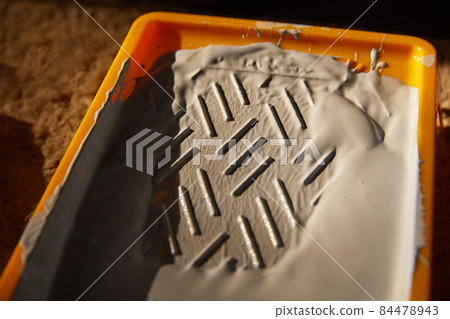 Closeup view of paint tray filled with gray paint. Tools for the painter and redecoration Closeup view of paint tray filled with gray paint. Tools for the painter and redecoration 84478943