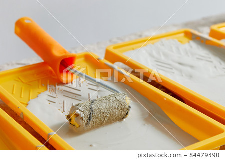 Closeup view of paint tray filled with gray paint. Tools for the painter and redecoration Closeup view of paint tray filled with gray paint. Tools for the painter and redecoration 84479390
