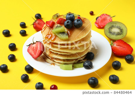 Concept of delicious dessert with pancakes on yellow background 84480464