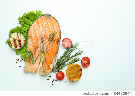 Tasty grilled salmon and ingredients on white background Tasty grilled salmon and ingredients on white background 84480944