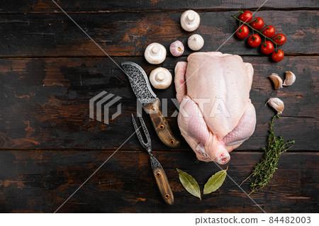 Fresh raw whole chicken, on old dark wooden table background, top view flat lay, with copy space for text 84482003