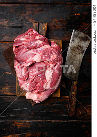 A large piece of raw meat, on old dark wooden table background, top view flat lay, with copy space for text 84482004