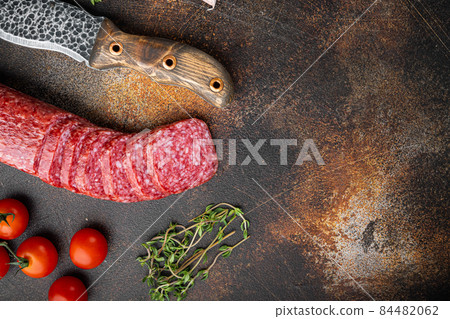 Dry salami sausage with fresh rosemary and spices, on old dark rustic table background, top view flat lay, with copy space for text Dry salami sausage with fresh rosemary and spices, on old dark rustic table background, top view flat lay, with copy space for text 84482062