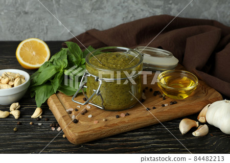 Pesto sauce and ingredients for cooking on wooden background Pesto sauce and ingredients for cooking on wooden background 84482213