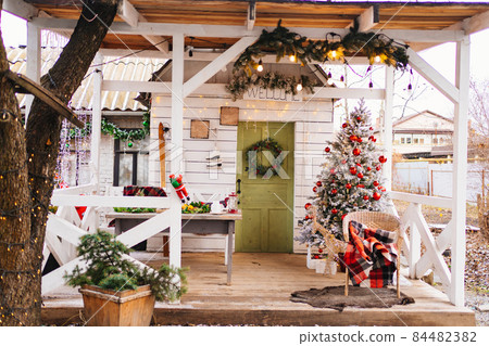the tradition of decorating the house for Christmas. Christmas tree on the porch the tradition of decorating the house for Christmas. Christmas tree on the porch 84482382