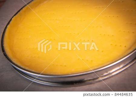 Metal fork makes holes in a raw pastry case in a metal baking tin Metal fork makes holes in a raw pastry case in a metal baking tin 84484635