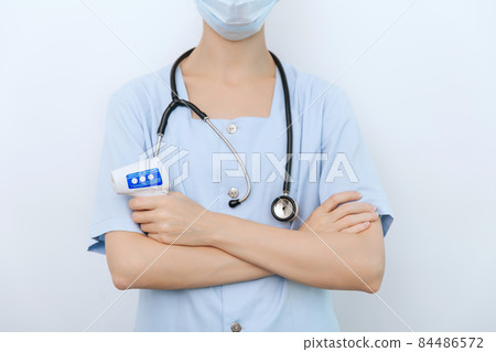 Temperature measurement gun in doctor hands. Close-up shot of doctor wearing protective surgical mask ready to use infrared isometric thermometer gun to check body temperature for virus symptoms. Temperature measurement gun in doctor hands. Close-up shot of doctor wearing protective surgical mask ready to use infrared isometric thermometer gun to check body temperature for virus symptoms. 84486572