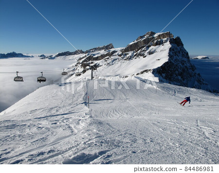 Mountain, sea of fog and staggering skier, Titlis region Mountain, sea of fog and staggering skier, Titlis region 84486981