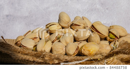 Pistachios in burlap sack on concrete table. Organic pistachios. Vegan Healthy food high protein. Dietary nutrition. Concept of nuts 84488738