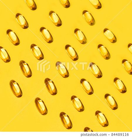 Yellow oval pills capsules vitamin Omega 3 over yellow Yellow oval pills capsules vitamin Omega 3 over yellow 84489116