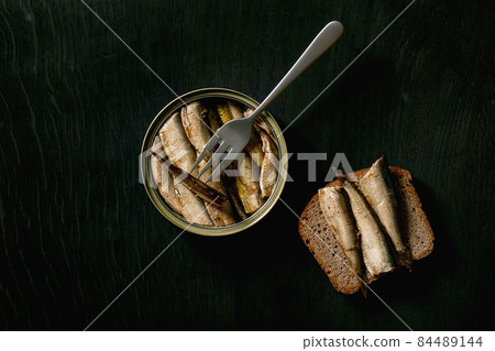 Open can with canned sprats in oil 84489144