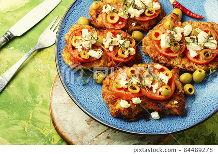 Meat schnitzel with cheese, olives and tomato 84489278