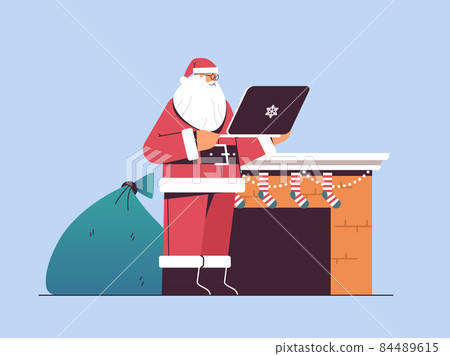 santa claus with gift box sack using laptop happy new year merry christmas holiday celebration concept 84489615