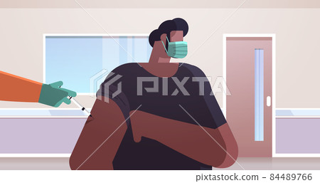 doctor hand vaccinating african american male patient in medical mask fight against coronavirus vaccine development 84489766