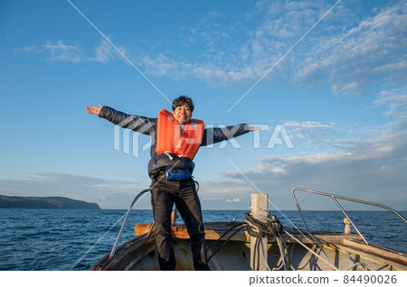 A person posing on a ship (taken off the coast of Noto, Ishikawa Prefecture) 84490026