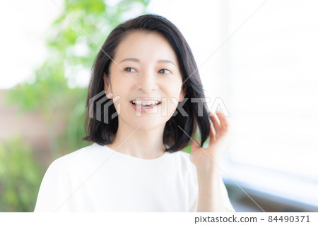 中年婦女手挽頭髮微笑 圖片合作:WEEK Shibadaimon(Sun Frontier Fudousan) 中年婦女手挽頭髮微笑 圖片合作:WEEK Shibadaimon(Sun Frontier Fudousan) 84490371