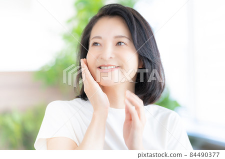 Middle-aged woman smiling with her hands on her cheeks Photo cooperation: WEEK Shibadaimon (Sun Frontier Fudousan) 84490377