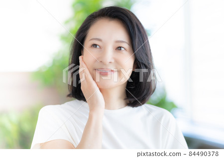 Middle-aged woman smiling with her hands on her cheeks Photo cooperation: WEEK Shibadaimon (Sun Frontier Fudousan) 84490378